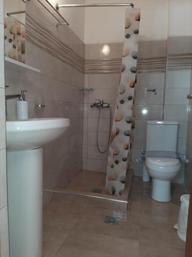 uma casa de banho com um lavatório e um WC em Melia studio 2 seafront apartment em Loutraki