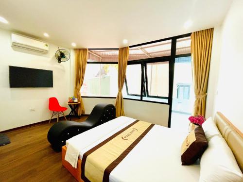 a bedroom with a bed and a couch and a tv at A&EM VILLA in Hanoi
