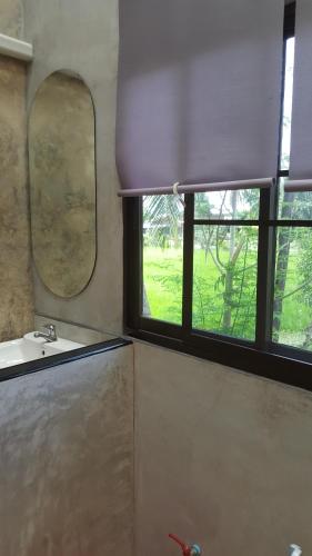 a bathroom with a sink and a window at Raina-Suanpa Lung Sood Farmstay in Ban Mot Deng