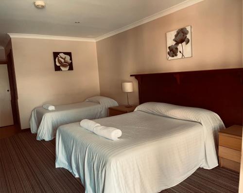 a hotel room with two beds with towels on them at Denmark Hotel in Denmark