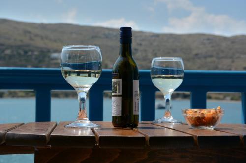 uma garrafa de vinho e dois copos numa mesa em Galaxy Hotel em Gavrio