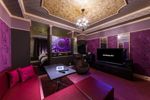 a living room with purple walls and a tv at Kashiba Hotel Flower Style (Adult Only) in Kashiba
