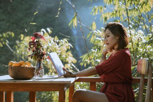 a woman sitting at a table reading a book at Gumi Ayu EcoStay in Munduk