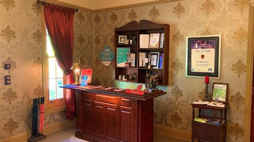 a room with a book shelf and a table with books at Bli Bli House Riverside Retreat in Twin Waters