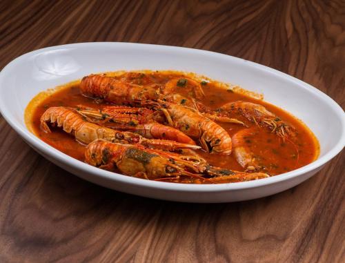 a bowl of food with lobster in a sauce at Aparthotel Miramare in Makarska