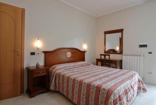 a bedroom with a bed and a dresser and a mirror at Albergo Villa Bianca in San Giovanni Rotondo