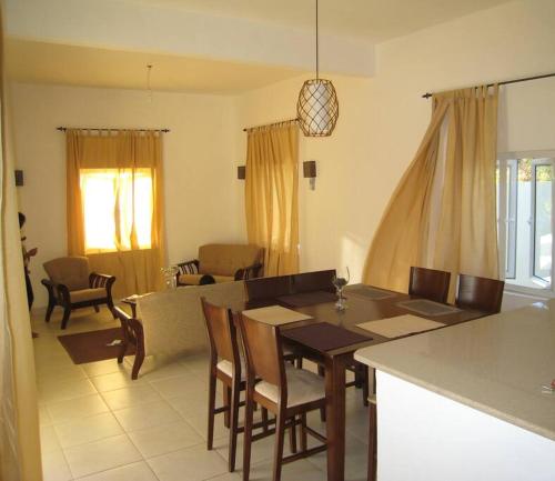 a kitchen and living room with a table and chairs at Villa Turquoise in Rivière Noire