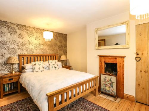 a bedroom with a bed and a mirror at Valentine Cottage in Aylsham