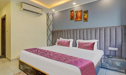 a bedroom with a large bed with pink pillows at Hotel Woodville Inn - Hotel in Mcleodganj in McLeod Ganj