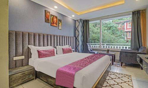 a bedroom with a large bed and a window at Hotel Woodville Inn - Hotel in Mcleodganj in McLeod Ganj
