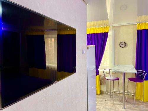 TV de pantalla plana grande colgada en la pared en Квартира в центре (р-н Аян Пассаж), en Temirtaū