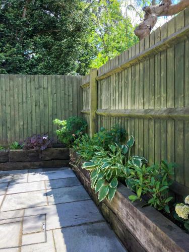 a wooden fence with a garden of plants at The Manor Barn in Northampton