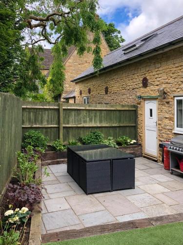 a garden with a black table on a patio at The Manor Barn in Northampton