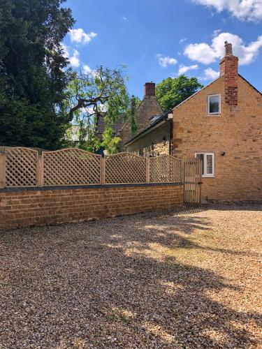 a brick fence in front of a house at The Manor Barn in Northampton