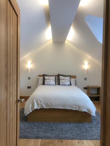 a bedroom with a bed with white sheets and a blue rug at The Manor Barn in Northampton