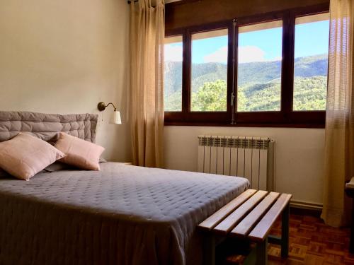 1 dormitorio con cama con banco y ventana en Apartament familiar - Els Encantats - Espot en Espot