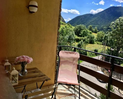 - un balcon avec une table et un vase de fleurs dans l'établissement Apartament familiar - Els Encantats - Espot, à Espot