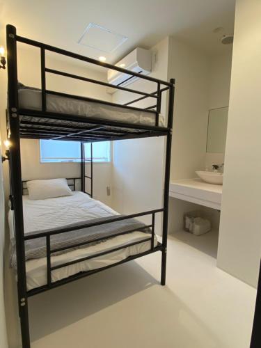 a bedroom with two bunk beds in a room at En- Hostel & Café bar in Amami