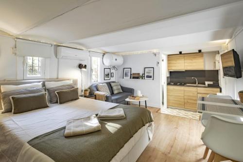 バルセロナにあるNEW Renovated COZY APPARTMENT CENTRICのベッドルーム(大型ベッド1台付)、リビングルームが備わります。