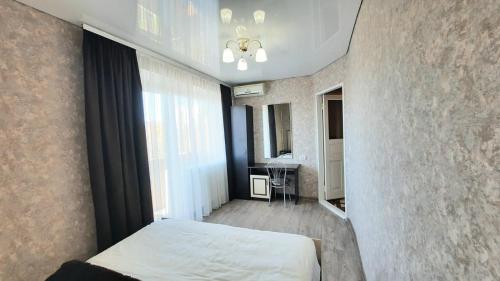 een slaapkamer met een bed en een groot raam bij Двухкомнатная квартира 500м от моря ул Парковая отчетные док in Chornomorsk