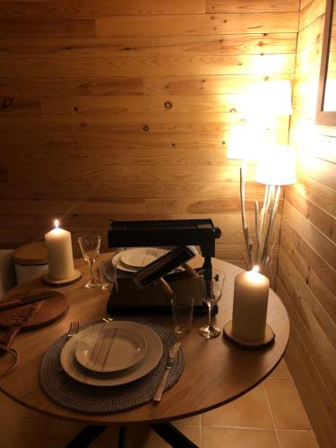 a table with two candles and a lamp on it at Cocon au cœur de Yvoire avec parking gratuit in Yvoire
