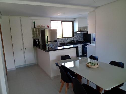 a kitchen with a table and a table and chairs at Portoparadise - Beach Class Eco life Residence in Porto De Galinhas