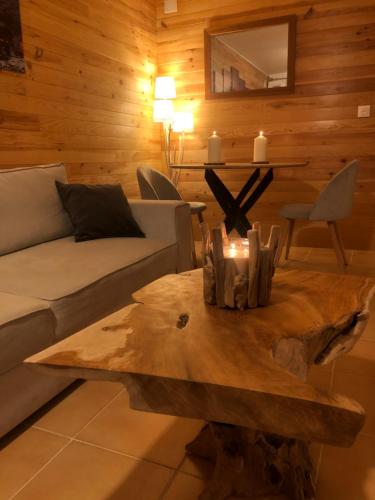 a living room with a couch and a wooden table at Cocon au cœur de Yvoire avec parking gratuit in Yvoire