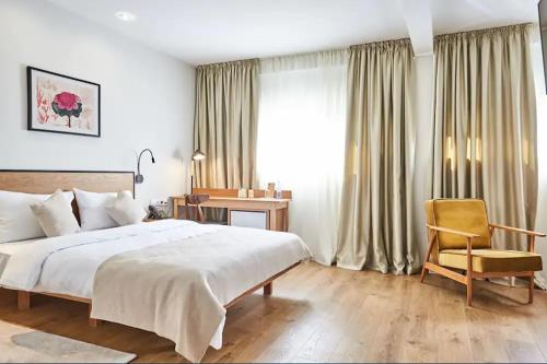 1 dormitorio con 1 cama, 1 silla y 1 ventana en Urban Park Hotels, en Tiflis