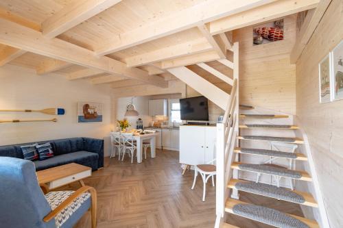a living room with a staircase in a tiny house at Domki nad morzem Otulone Słońcem in Rowy