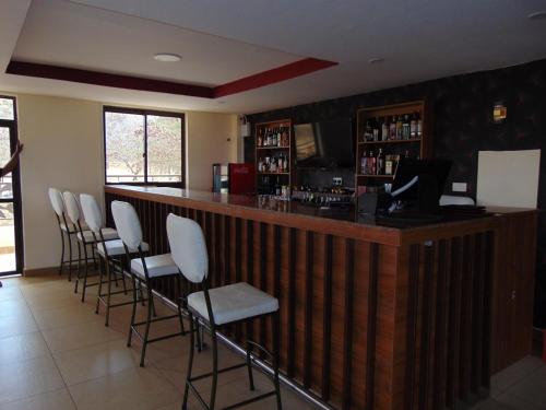 a bar with white bar stools in a restaurant at KILIMANI BREEZE HOTEL in Wote