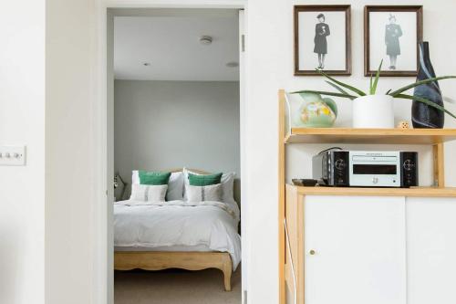 a bedroom with a bed and a shelf with a microwave at The Old Post Office Apartment in Falmouth