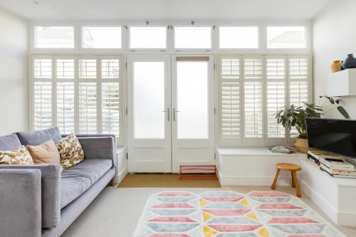 a living room with a couch and a tv at The Old Post Office Apartment in Falmouth