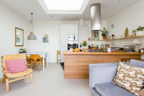 a kitchen and living room with a couch and a table at The Old Post Office Apartment in Falmouth