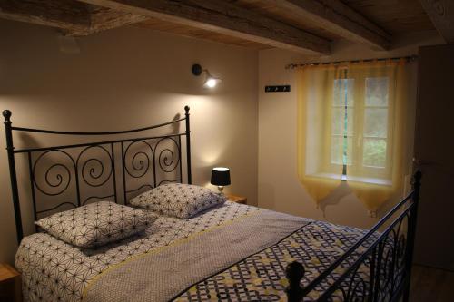 a bedroom with a bed and a window at Gîte du moulin in Chénelette