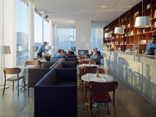 a restaurant with couches and tables and people sitting at tables at PM & Vänner Hotel in Växjö