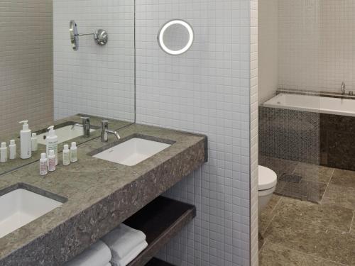 a bathroom with a sink and a toilet and a tub at PM & Vänner Hotel in Växjö