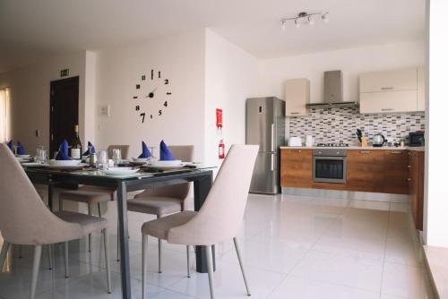 una sala da pranzo con tavolo e sedie in cucina di Modern 3 bedroom with AC apartment a Żabbar