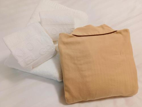 two towels sitting next to each other on a bed at Akasaka Urban Hotel in Tokyo