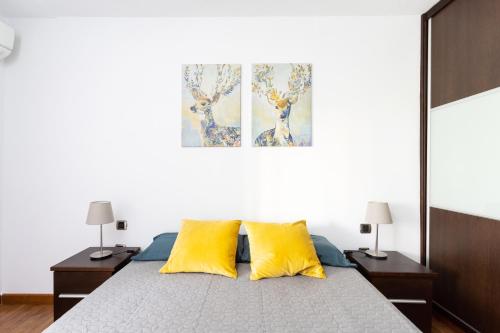 ein Schlafzimmer mit einem Bett mit zwei gelben Kissen in der Unterkunft Home2Book Bright Center Apartment Santa Cruz in Santa Cruz de Tenerife