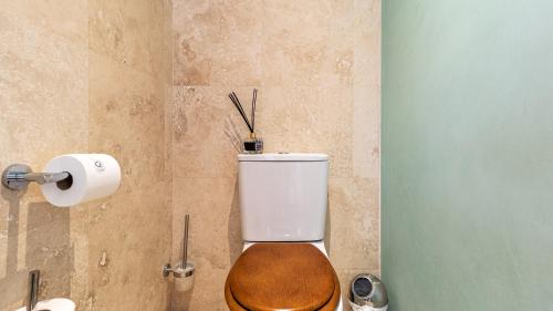 a bathroom with a toilet with a wooden toilet seat at The Glen Boutique Hotel & Spa in Cape Town