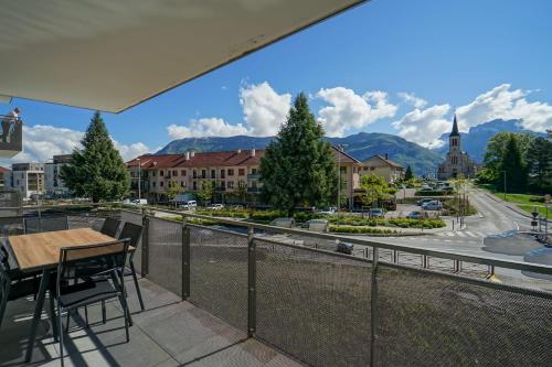 a balcony with a table and chairs and a view of a city at La Douce Folie - Apartment for 4 to 5 people in Sevrier in Sévrier