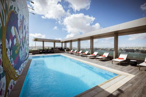 a swimming pool on the roof of a building at Centro Mada Amman by Rotana in Amman