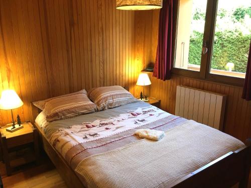 une chambre avec un lit avec deux lampes et une fenêtre dans l'établissement Le Nantoran, à Praz-sur-Arly