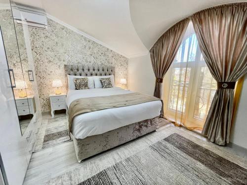 a bedroom with a bed and a large window at Premier City Apart Hotel Chisinau in Chişinău