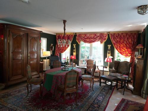 ein Esszimmer mit einem Tisch und Stühlen sowie ein Zimmer mit einem Fenster in der Unterkunft Gästehaus "Villa am Eggenbach" Familie Heiss in Eggenbach
