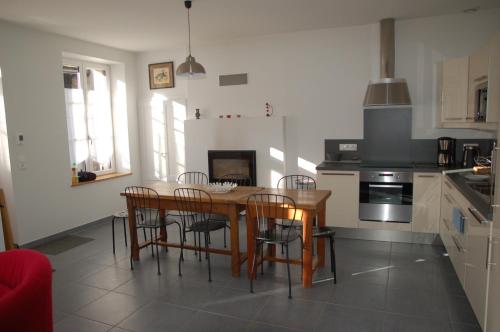 une cuisine avec une table et des chaises en bois dans l'établissement Longère avec jardin - Vallée du Loir, à Villiers-sur-Loir