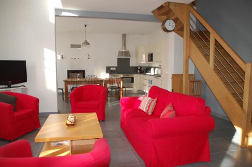 un salon avec des chaises rouges et une table dans l'établissement Longère avec jardin - Vallée du Loir, à Villiers-sur-Loir