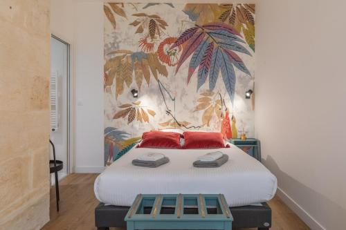 a bedroom with a bed and a painting on the wall at Gabylou in Bordeaux
