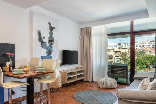 een woonkamer met een tafel en een televisie bij Chada Morro Jable in Morro del Jable