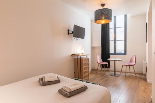 a bedroom with a bed and a table and chairs at Gabylou in Bordeaux